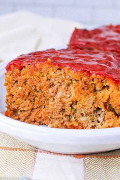 a close up of a piece of meatloaf on a plate with ketchup