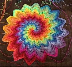 a colorful crocheted flower is on the ground