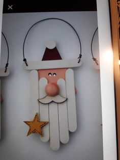 a wooden santa clause hanging from the side of a wall next to a gold star