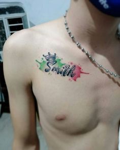 a man with a name tattoo on his chest and the word smile painted in different colors