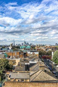 the city is full of tall buildings and some clouds in the sky above it,