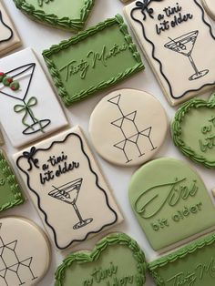 decorated cookies are arranged in the shape of martinis and cocktail glasses with green trim