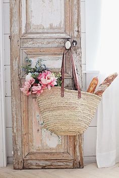 a basket with flowers in front of an old door