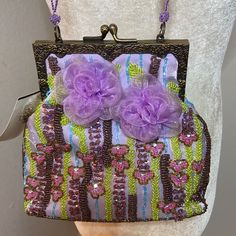 Beautiful Beaded Lilac Dress Bag By Tahari. Adorned With Chiffon Flowers On Both Sides. Lilac Beaded Straps. Brass Colored Hardware. Metallic Gold And Copper Colored Beads As Well As Beads In Hues Of Blue, Chartreuse And Pink Complete The Color Scheme. There Are A Couple Of Tiny Loose Threads Here And There But Hardly Noticeable And That Is The Way The Purse Came. Its Missing Some Blue Beads Near Side But A Again, Not Noticeable When Worn. Never Been Worn & Otherwise In Excellent Condition. Embroidered Evening Bag For Summer, Elegant Purple Party Bag, Embellished Bags For Formal Occasions In Summer, Embellished Bags For Formal Summer Events, Purple Evening Bag For Wedding, Summer Party Embellished Evening Bag, Elegant Embellished Summer Bags, Summer Formal Embellished Bags, Purple Wedding Evening Bag