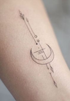 a small tattoo on the ankle of a woman with an arrow and circle in it