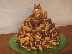 a cake made to look like a cat sitting on top of a pile of cookies