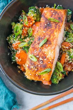 salmon, broccoli and carrots in a bowl with sesame seeds