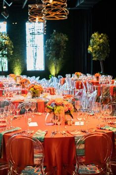 the tables are set with orange linens and place settings