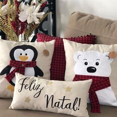 three pillows with different designs on them sitting on a couch in front of a christmas tree