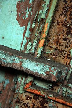 an old rusty door with peeling paint on it