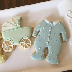 decorated cookies in the shape of baby's carriage and teddy bear on a tray