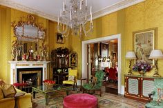 a living room filled with lots of furniture and a chandelier hanging from the ceiling