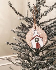 a birdhouse ornament hanging from a christmas tree