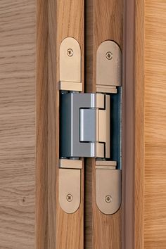 a close up of a wooden door with a metal hinge on the front and side