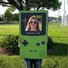 a woman holding up a video game controller costume for the cameraman in front of her