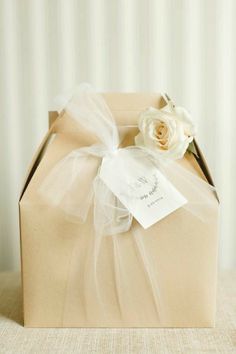 a brown box with a white rose on it and a tag attached to the top