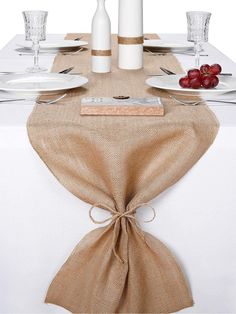 the table is set with white plates and silverware, napkins, and wine glasses