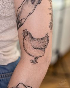 a woman with a tattoo on her arm has a bird and a toucan