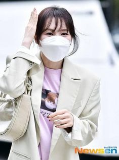 a woman wearing a face mask while walking down the street