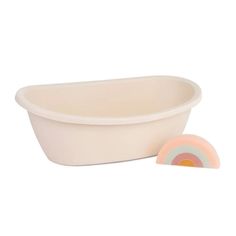 a white tub next to a pink and yellow bowl with a rainbow design on the rim