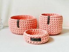 three pink knitted baskets sitting next to each other