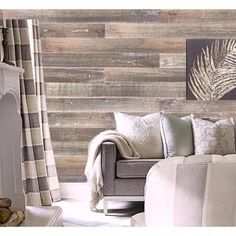 a living room scene with focus on the couch and wall coverings that look like wood