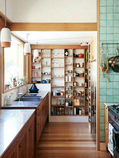 a kitchen with wooden cabinets and shelves filled with dishes