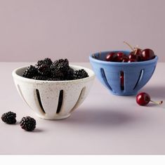 two bowls filled with blackberries next to each other