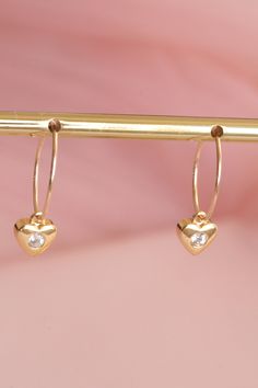 Mini gold-plated hoop earrings decorated with a fine gold-plated heart. They are a minimalist and refined jewel. They are 15 mm in diameter. For pierced ears. The heart is 8 mm high and 7 mm wide. Their sober and minimalist look makes these hoop earrings the perfect gift for a special occasion! My jewelry is assembled by hand in my workshop in Paris. All my jewelry is shipped in a pretty pink suede pouch. To preserve the shine of your jewelry, avoid contact with perfume, cosmetics or chemicals.