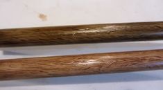 two wooden baseball bats sitting next to each other