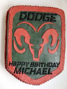 a red and green birthday cake with an image of a ram on it's side