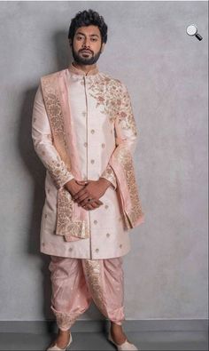 a man in a white and pink sherwa with gold details on his jacket