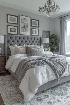 a bedroom with gray walls, white bedding and chandelier in the corner