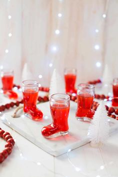 a table topped with glasses filled with liquid and candy canes on top of it