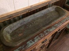 an old wooden cabinet with some writing on the top and bottom, sitting in a room