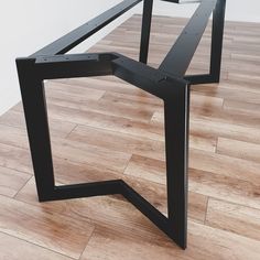 a black table sitting on top of a hard wood floor