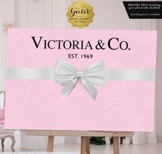 a pink sign with a white bow on it that says victoria & co est 1956