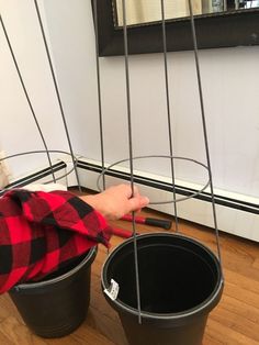 a boy is playing with some buckets on the floor