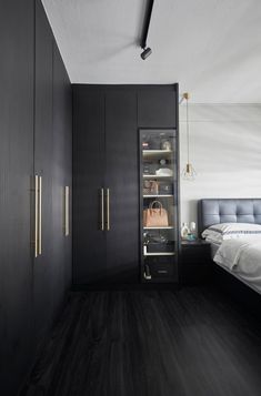 a bedroom with dark wood floors and white walls, along with built in closets