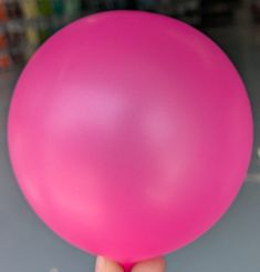 a person holding a pink balloon in their hand