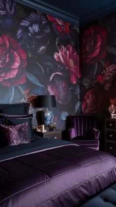 a bed with purple and red flowers on the wall next to a night stand in front of it