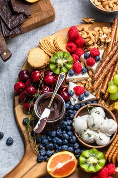 a platter filled with fruit, crackers and nuts