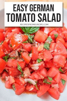 a white plate topped with sliced tomatoes and basil