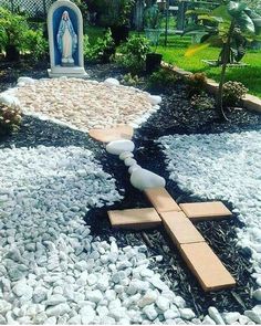 a garden with rocks, stones and a cross in the middle that is made out of wood