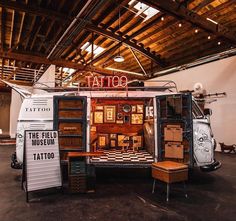 the inside of a tattoo shop with lots of items on display and signs in front of it