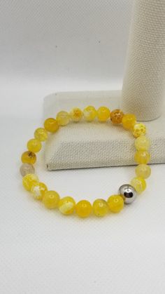 Meaning of the yellow agate stone:  This gem represents and signifies kindness, joy and optimism. Even the vast majority of times it is associated with wisdom, creativity and general knowledge, for this reason, it is thought to help balance the chakras that clear or clear the mind.  This bracelet has been elaborated with 8mm Yellow Agate cracked beads, with stretch elastic cord and a stainless steel bead with Coly's Touch logo.  Made to order in different sizes. Nice gift for any occasion.  CARE INSTRUCTIONS  To maintain the order quality of your new bracelet, please: - Roll bracelet On and Off, be sure to not overstretch the elastic cord.  - Avoid contact with water, perfumes and other chemicals.  - Remove when sleeping, exercising or doing other physically strenuous activities. - Store y Cheap Yellow Beaded Bracelets With Spacer Beads, Amber Agate Gemstone Beaded Bracelets, Spiritual Amber Agate Bracelets, Amber Agate Gemstone Bracelets, Amber Agate Beaded Bracelets With Gemstone Beads, Amber Bracelets With Natural Stones For Meditation, Amber Agate Hand-strung Beaded Bracelets, Agate Beaded Bracelets For Healing, Healing Agate Beaded Bracelets