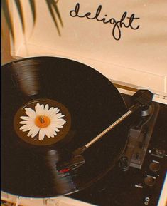 an old record player with a flower on the side and words delight written on it