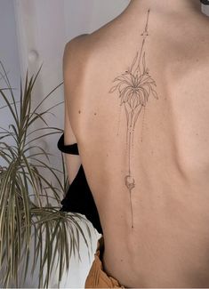 a woman's back with a flower tattoo on it