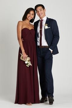 a man and woman in formal wear standing next to each other posing for the camera