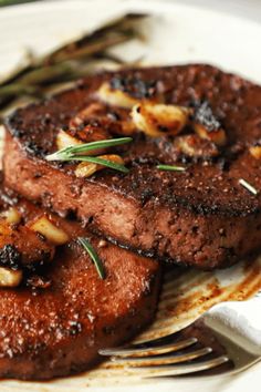 two pieces of steak on a plate with a fork